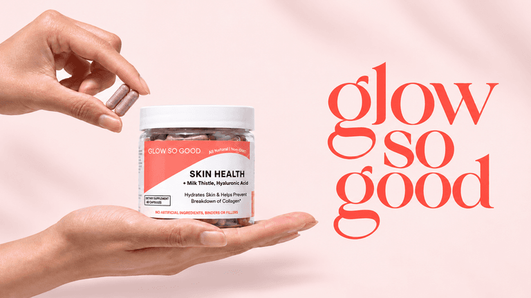 A hand holding a bottle of skin health capsules with the brand name displayed
