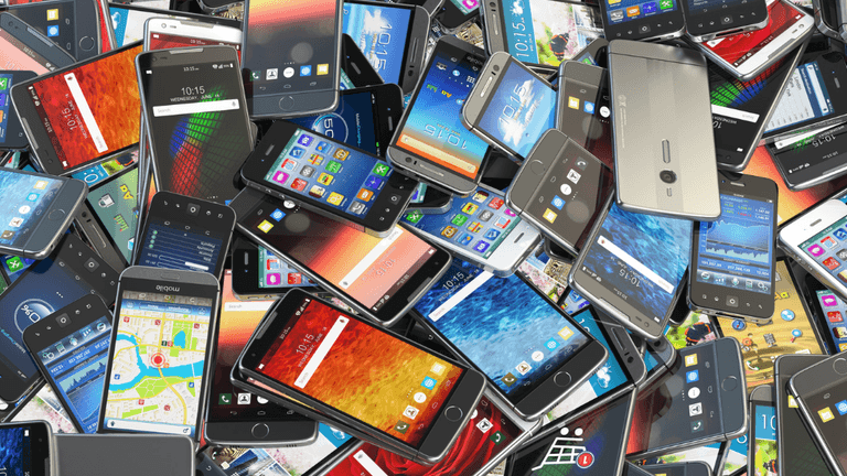 A chaotic pile of smartphones displaying various colorful screens and apps.