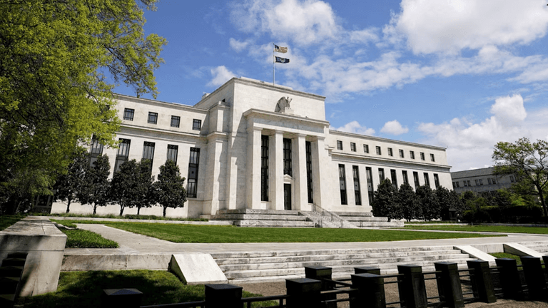 Exterior view of the Federal Reserve building with flag and trees in foreground