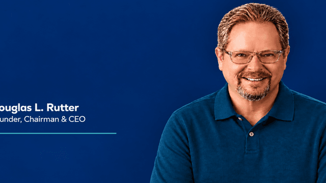Smiling man in a blue shirt against a blue background, labeled as CEO.