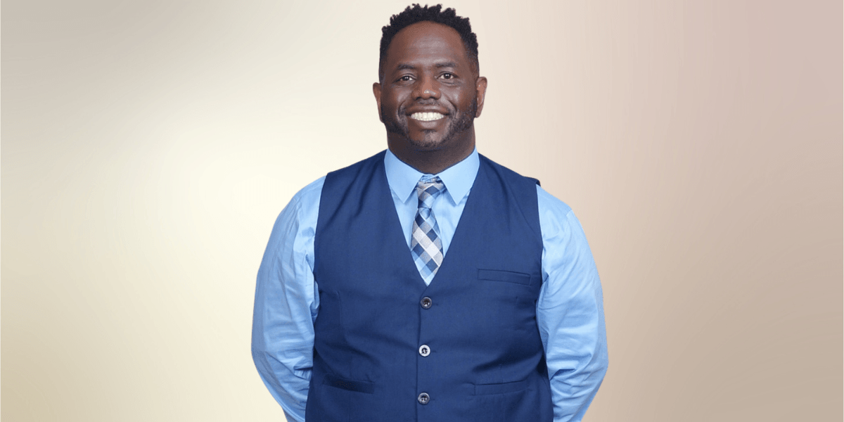 The image features Rashad Woods, host of The T.R.O.N. Podcast, wearing a blue vest, smiling confidently against a soft backdrop.