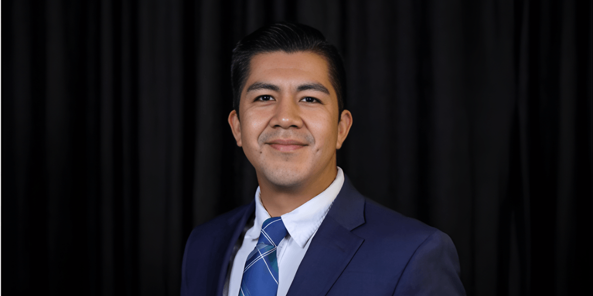 Juan Misael Gutierrez, CEO of MIB Immigration, in professional attire, smiling confidently.