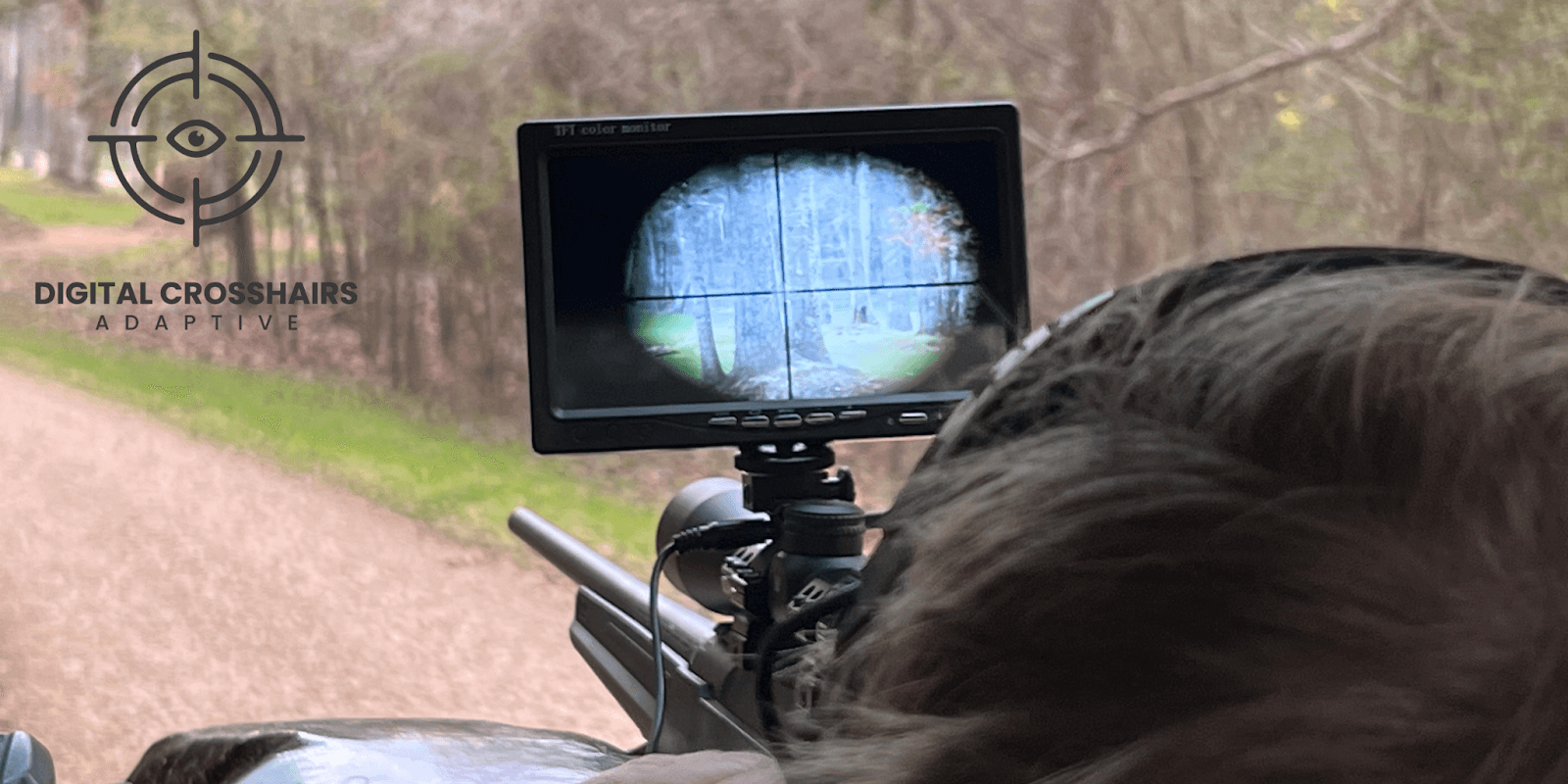 A person uses a Digital Crosshairs 1000SA rifle scope, viewing through a monitor, helping disabled individuals engage in hunting sports.