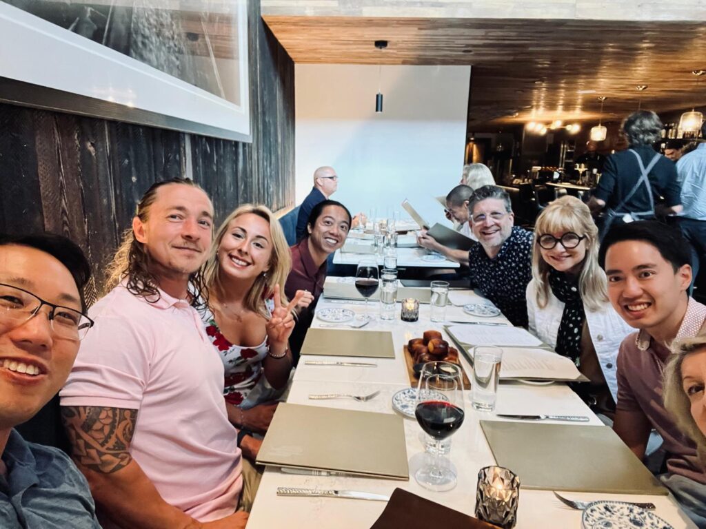 A group of people enjoying a meal at a restaurant, smiling and posing for a photo.