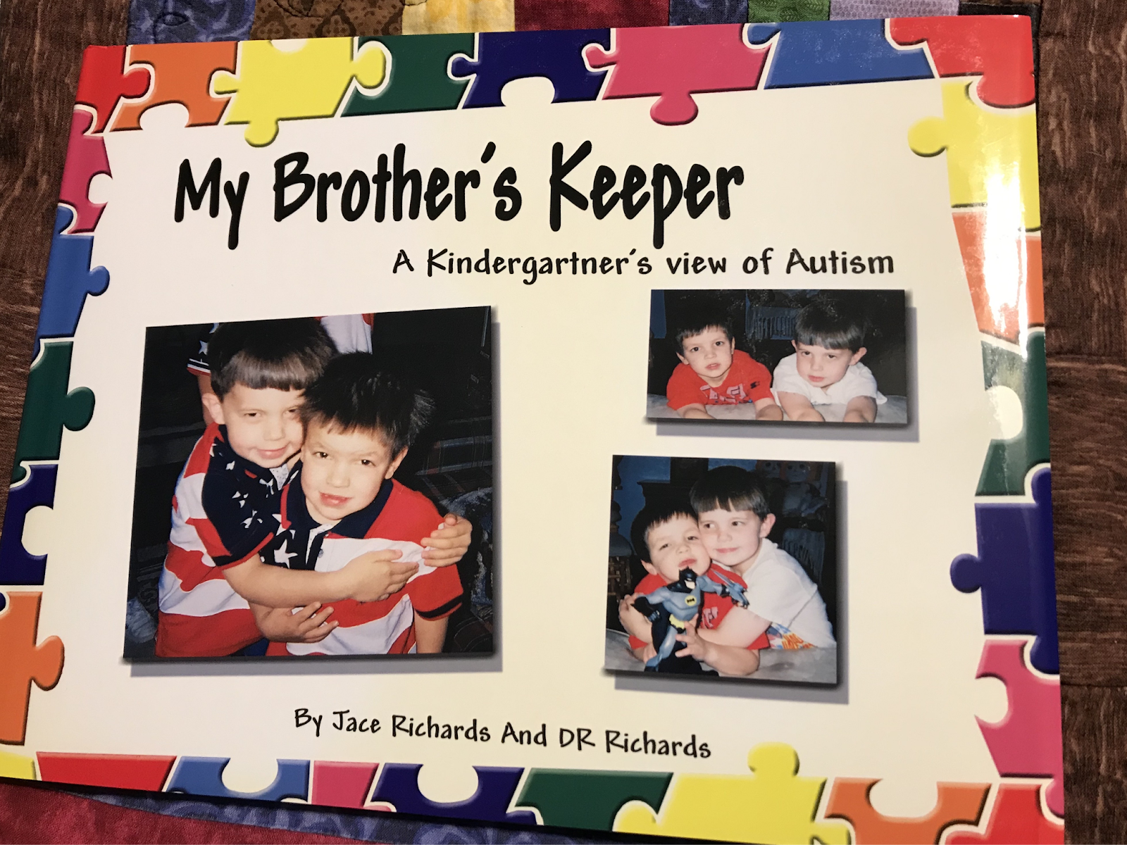 Cover of the book 'My Brother's Keeper: A Kindergartner's View of Autism' featuring a colorful puzzle piece border. The cover includes photos of two young boys hugging and playing together, with the title and authors' names below.