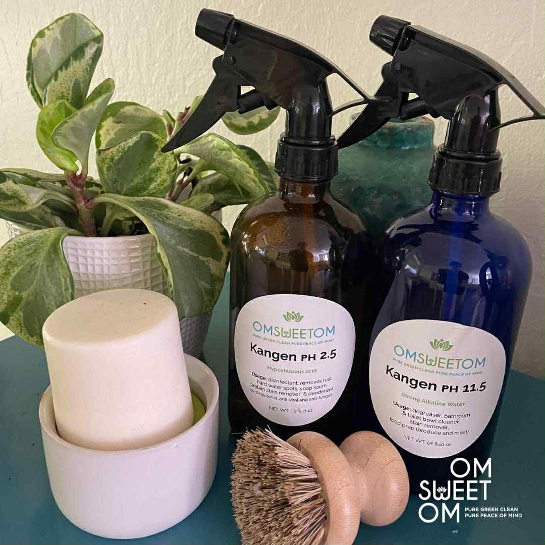 Bottles of OM Sweet OM Kangen PH 2.5 and Kangen PH 11.5, alongside natural cleaning brushes, highlighting sustainable and eco-friendly cleaning products.