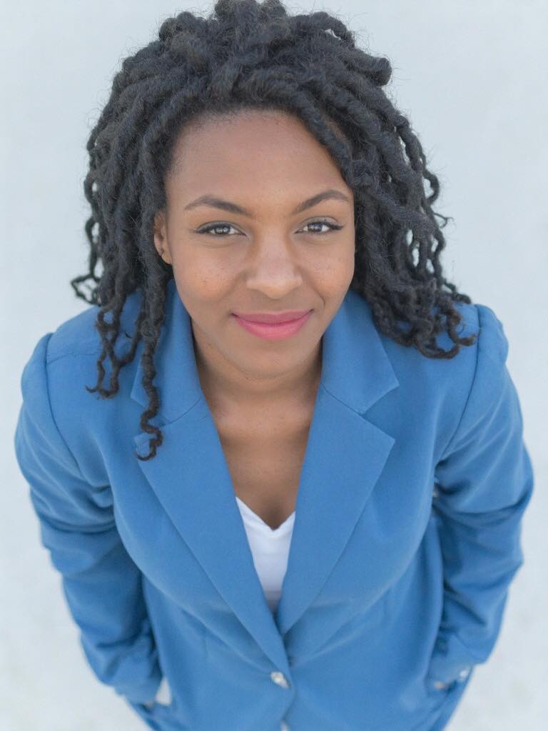 Professional portrait of Qiana Tompkins, business consultant, wearing a blue suit and smiling confidently.