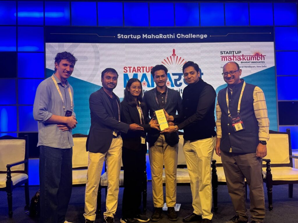 "Award ceremony at the Startup MahaRathi Challenge, where a group of entrepreneurs is celebrating after receiving an award for their innovative startup."