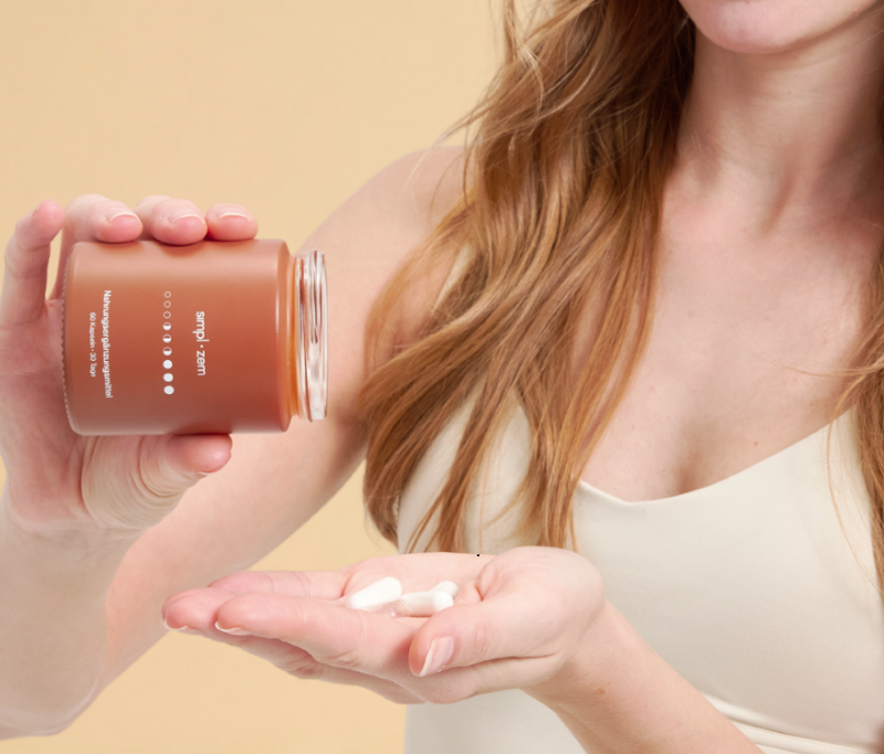A woman holding Simpl.bio supplements, emphasizing the brand's commitment to empowering women's health with science-backed solutions for appetite control, metabolism, and overall wellness.