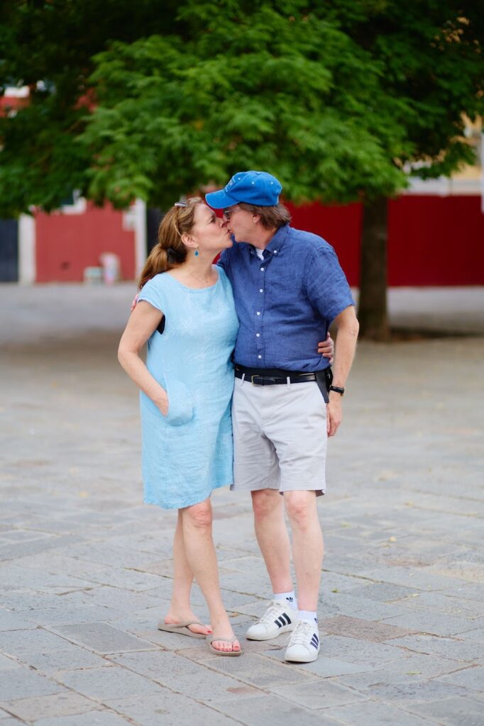 Couple sharing a kiss while exploring historic streets in Spain.
