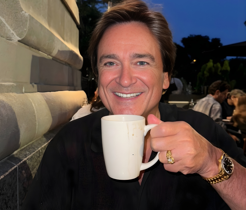 Man holding a coffee cup beside the RevPropeller logo, symbolizing faith-based financial education and empowerment for pastors.