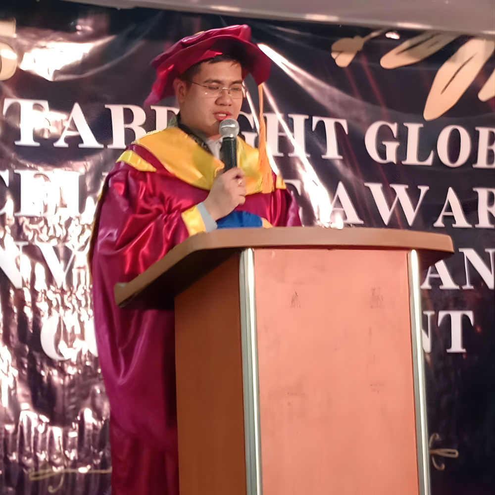 Dr. Alvin B. Punongbayan delivering a speech at an Instabright awards ceremony in academic regalia.