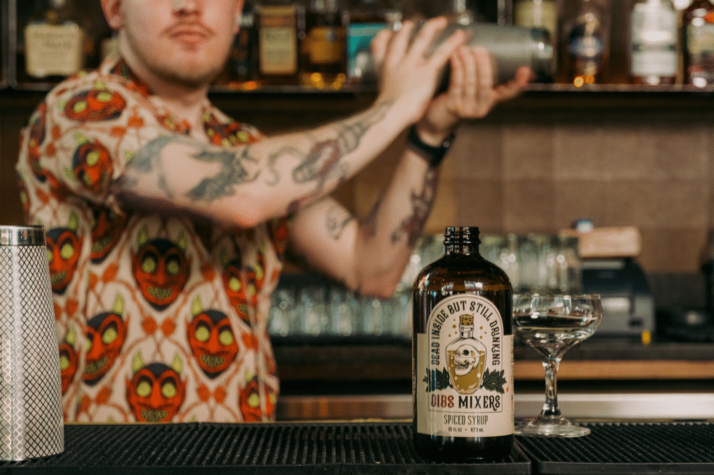 Bartender shaking a cocktail with DIBS Mixers Spiced Syrup.