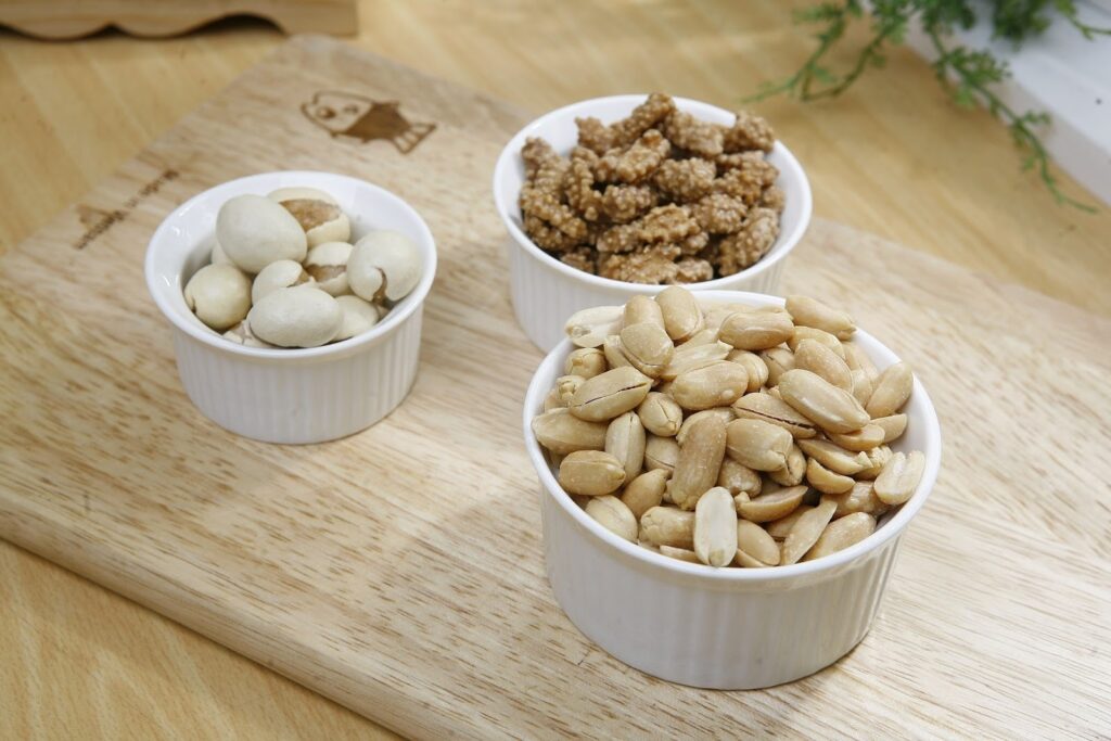 Dry fruits: "Variety of premium dry fruits including macadamia, peanuts, and sweetened walnuts from NUTSOUQ."