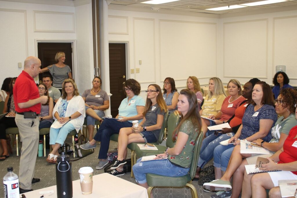 Dr. Drew Gold engaging with an audience in a training session on emotional intelligence.