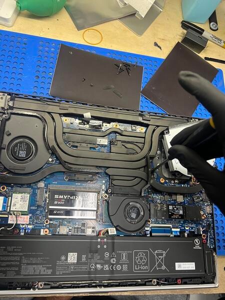 Technician working on a laptop motherboard repair at FixStop.