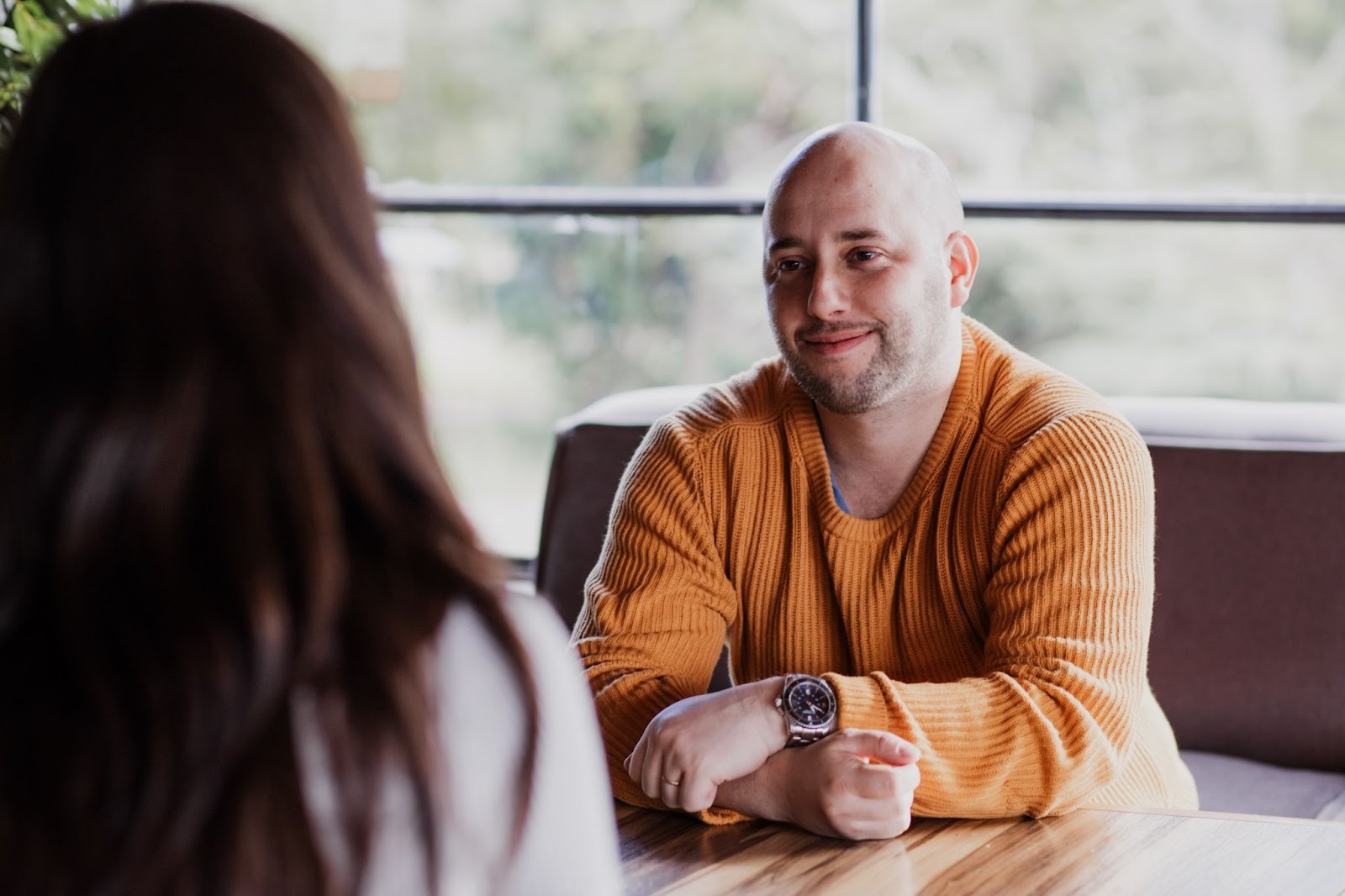 Mateo Silvera in a relaxed conversation with a person at a cafe.