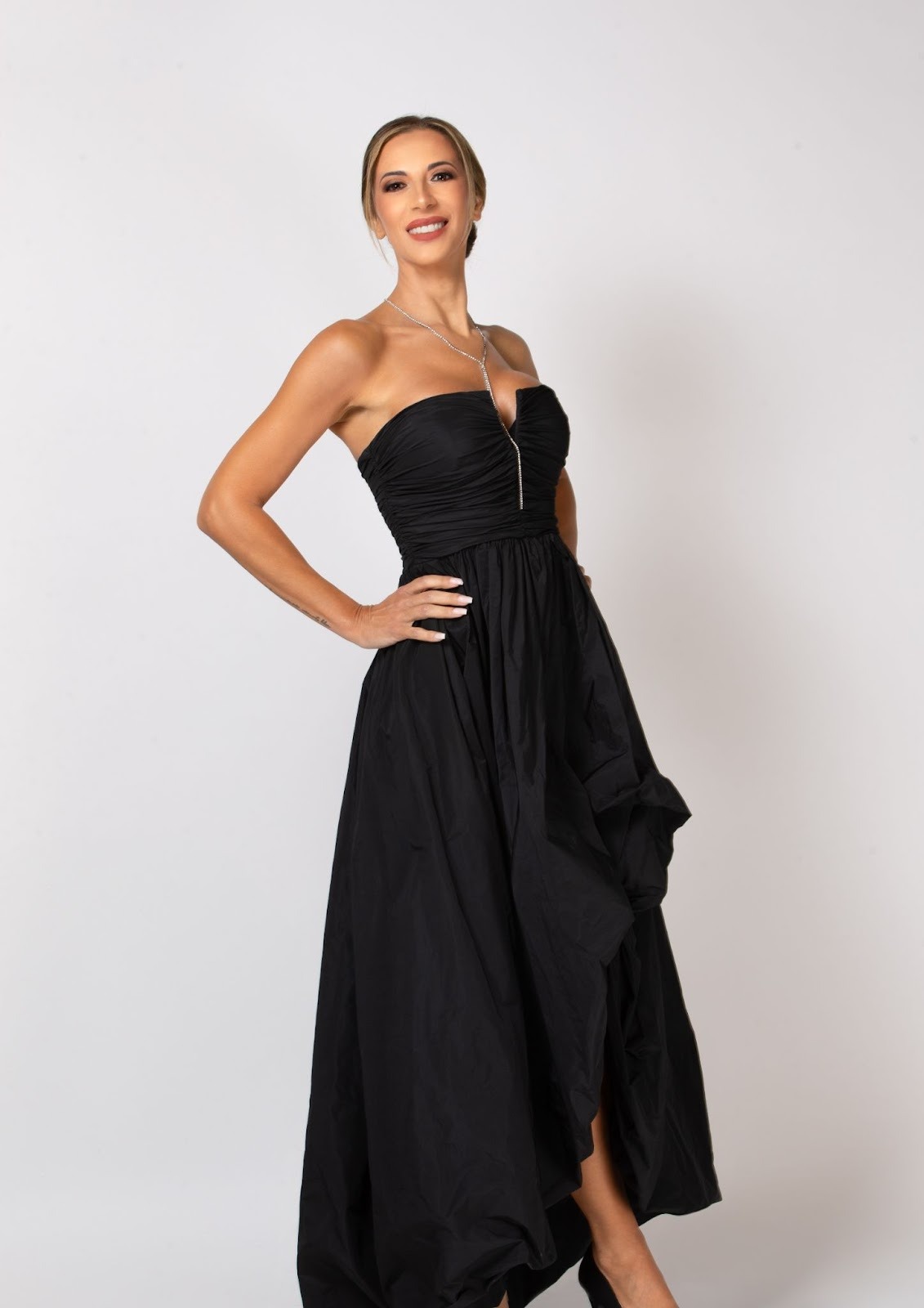 Valeria Petza strikes a powerful yet elegant pose in a black strapless gown, highlighting her stature and elegance.