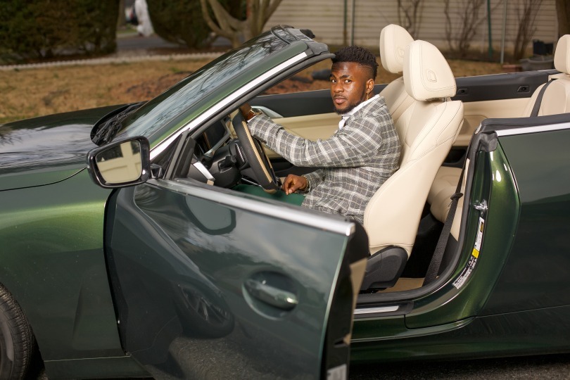 Miracle Ighalo inside a luxury car, symbolizing success and achievement in the tech industry.