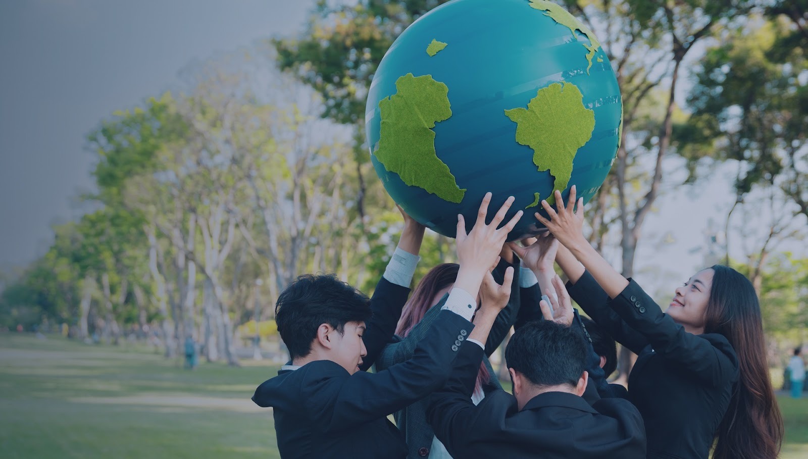 A group of young professionals lifting a globe, symbolizing global youth empowerment and collaboration.
