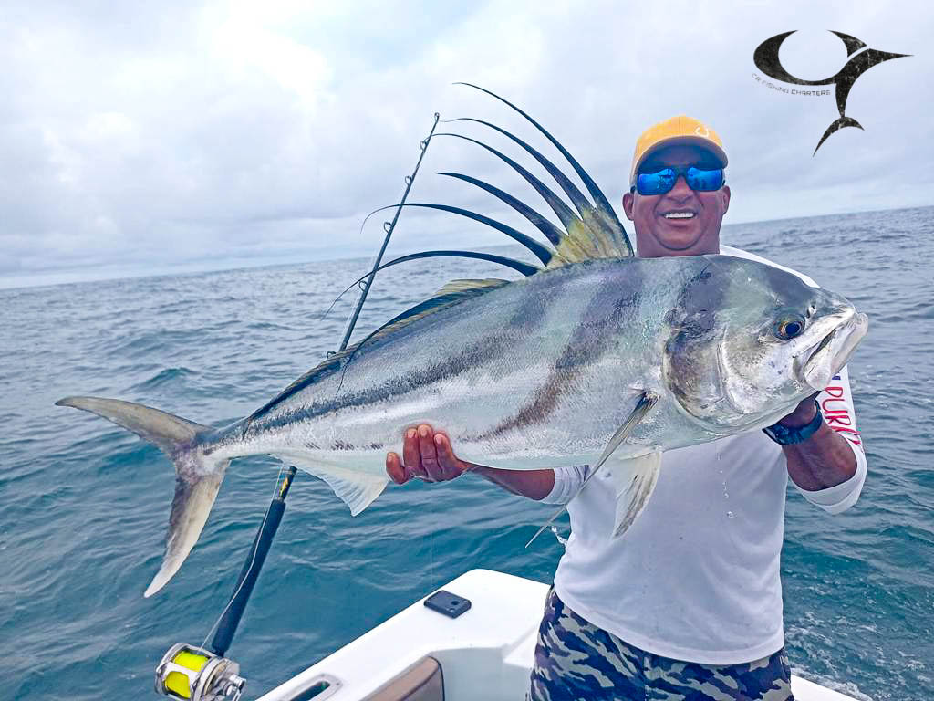 Angler holding a vibrant mahi-mahi, a colorful tropical fish, on a boat.