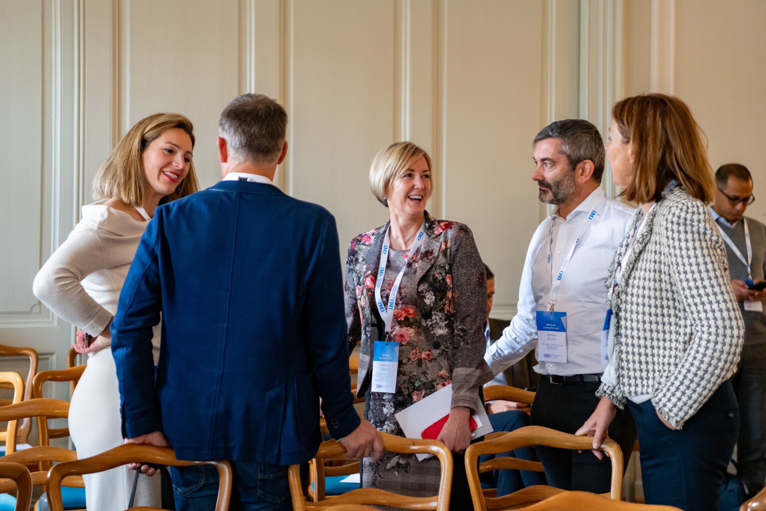 A group of professionals networking and discussing at an event.
