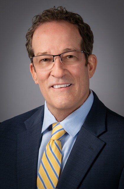 Professional headshot of financial planner John G. Ziesing in a suit and striped tie.