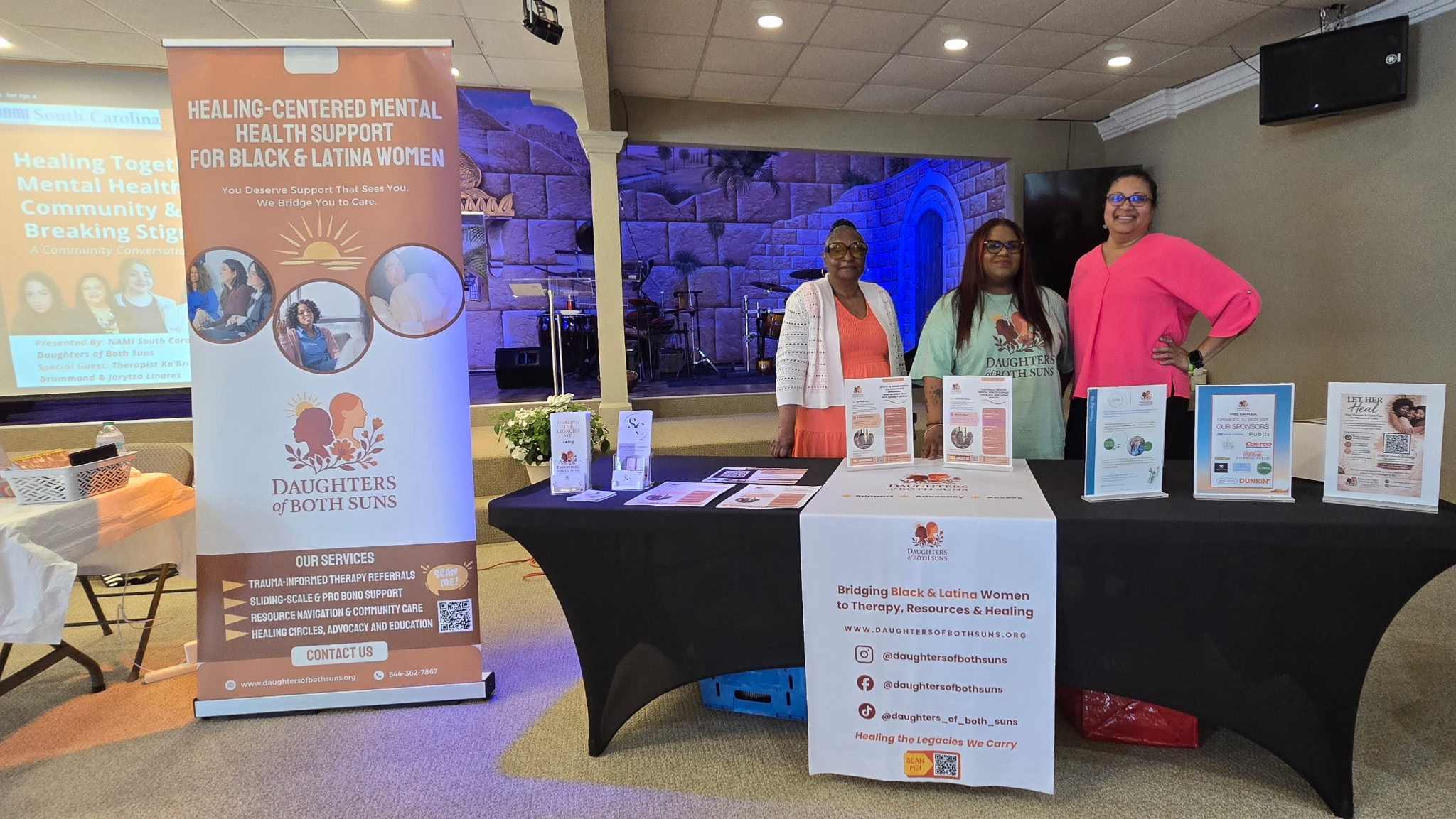 Daughters of Both Suns community outreach table promoting mental health support for Black and Latina women.