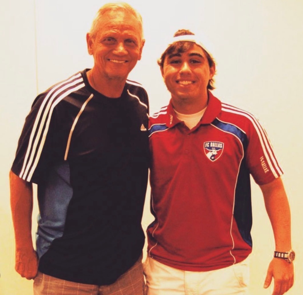 Brad Namdar posing with older coach indoors, both smiling in team apparel