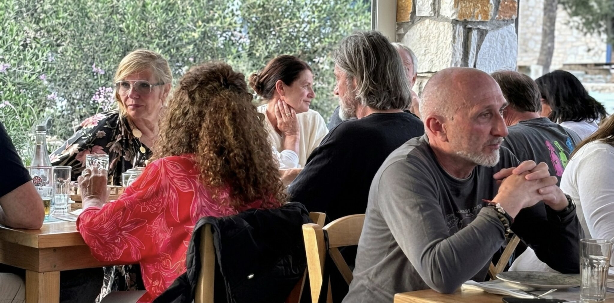Diners enjoy meals at tables inside Souvlaki Dryos, overlooking the ocean on Paros Island.