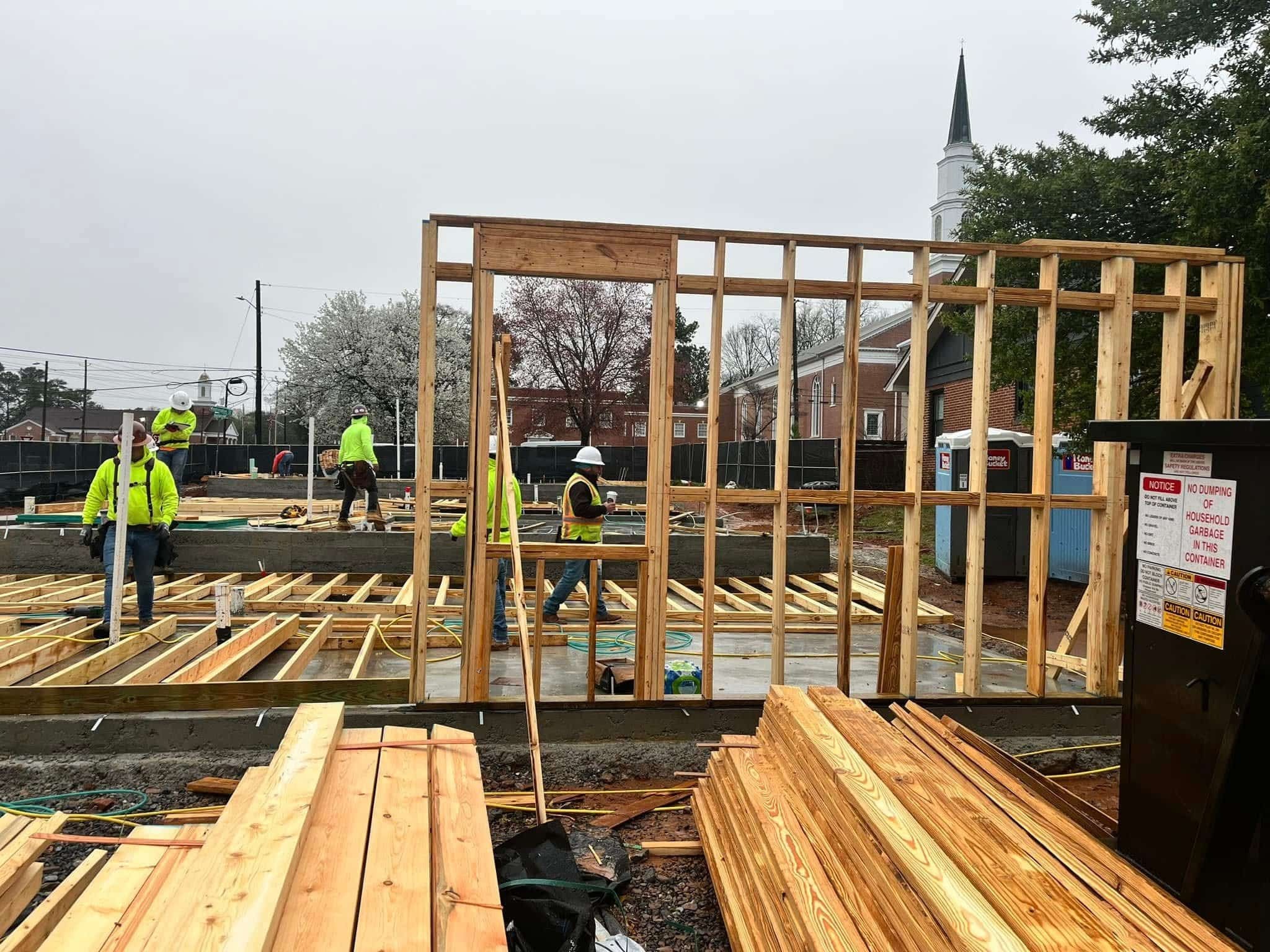 Construction workers build a house at a site, showcasing Bowser Construction Group's commitment to quality service.
