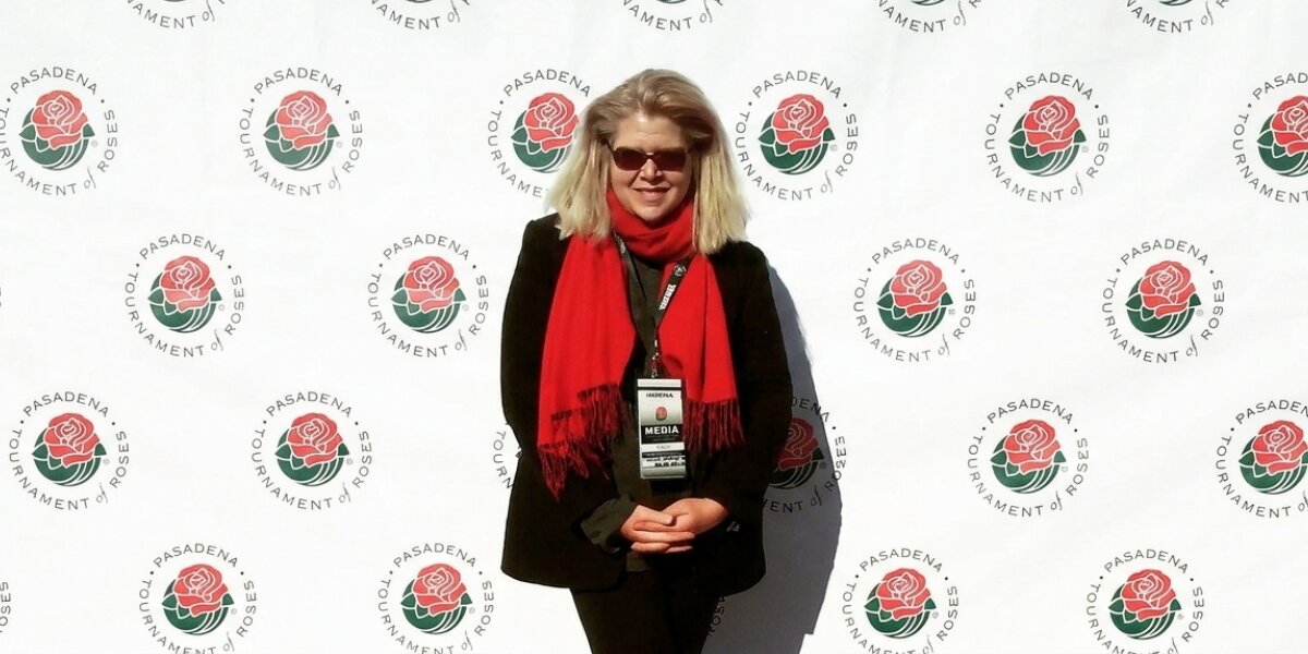 Janet Walker at Pasadena Tournament of Roses media event wearing red scarf and black suit.