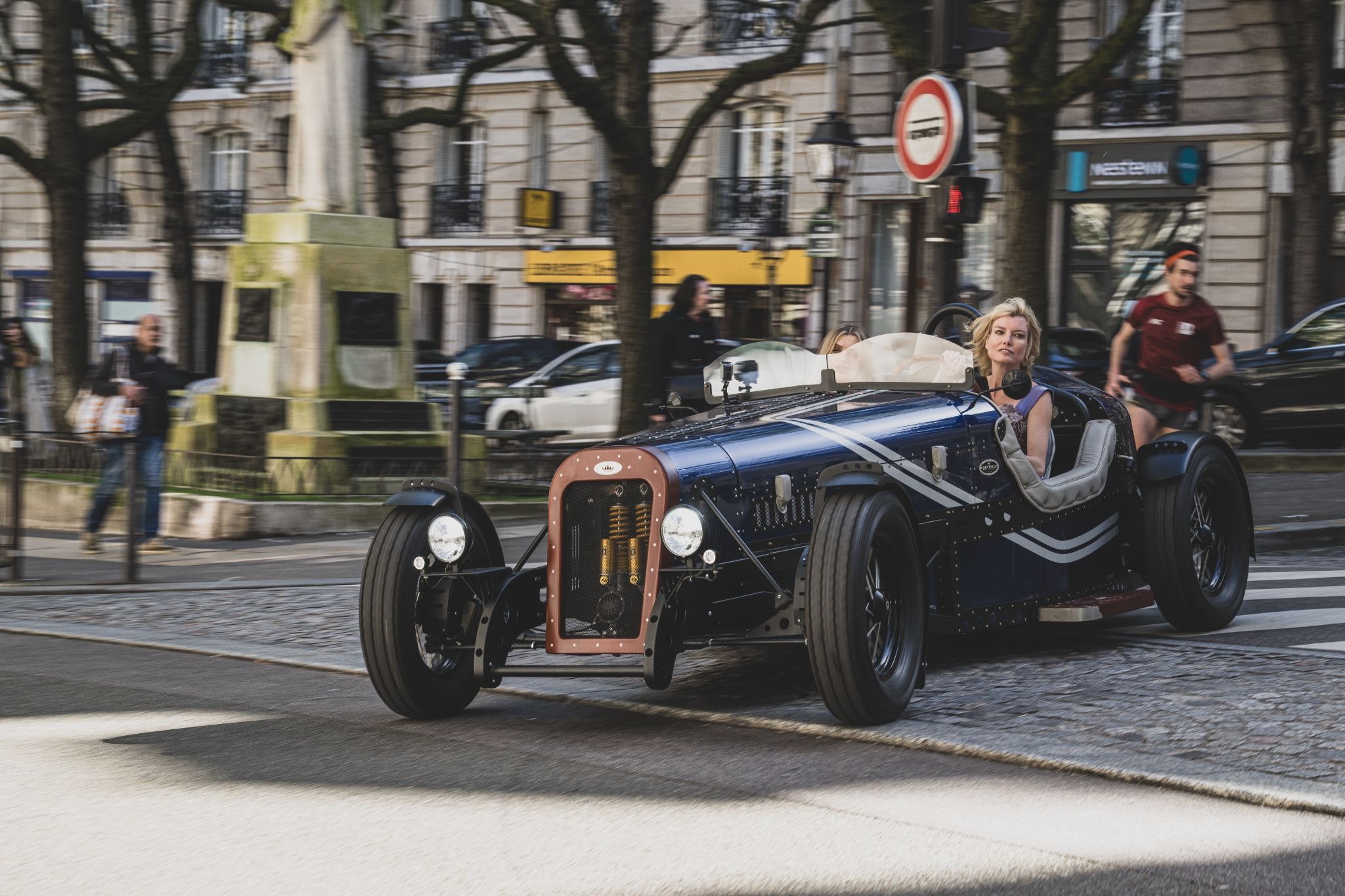 Eugenia Kuzmina driving DEVINCI car through Paris street with urban motion blur