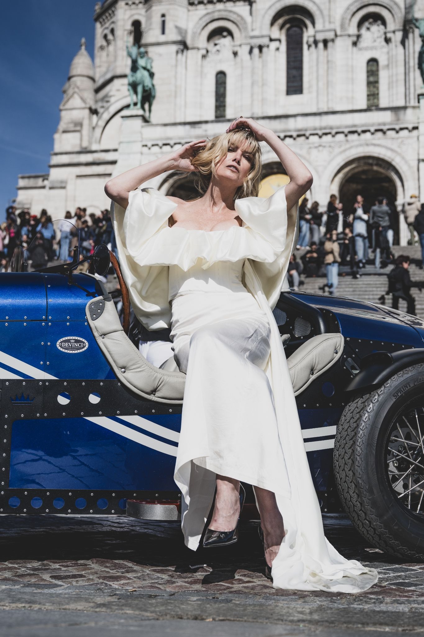 Eugenia Kuzmina seated in DEVINCI car near Sacré-Cœur, wearing elegant white dress