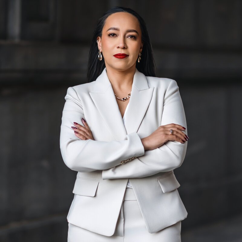 Tina Patterson in a white suit with red lipstick, exuding confidence as she discusses strategic legal counsel for leaders.