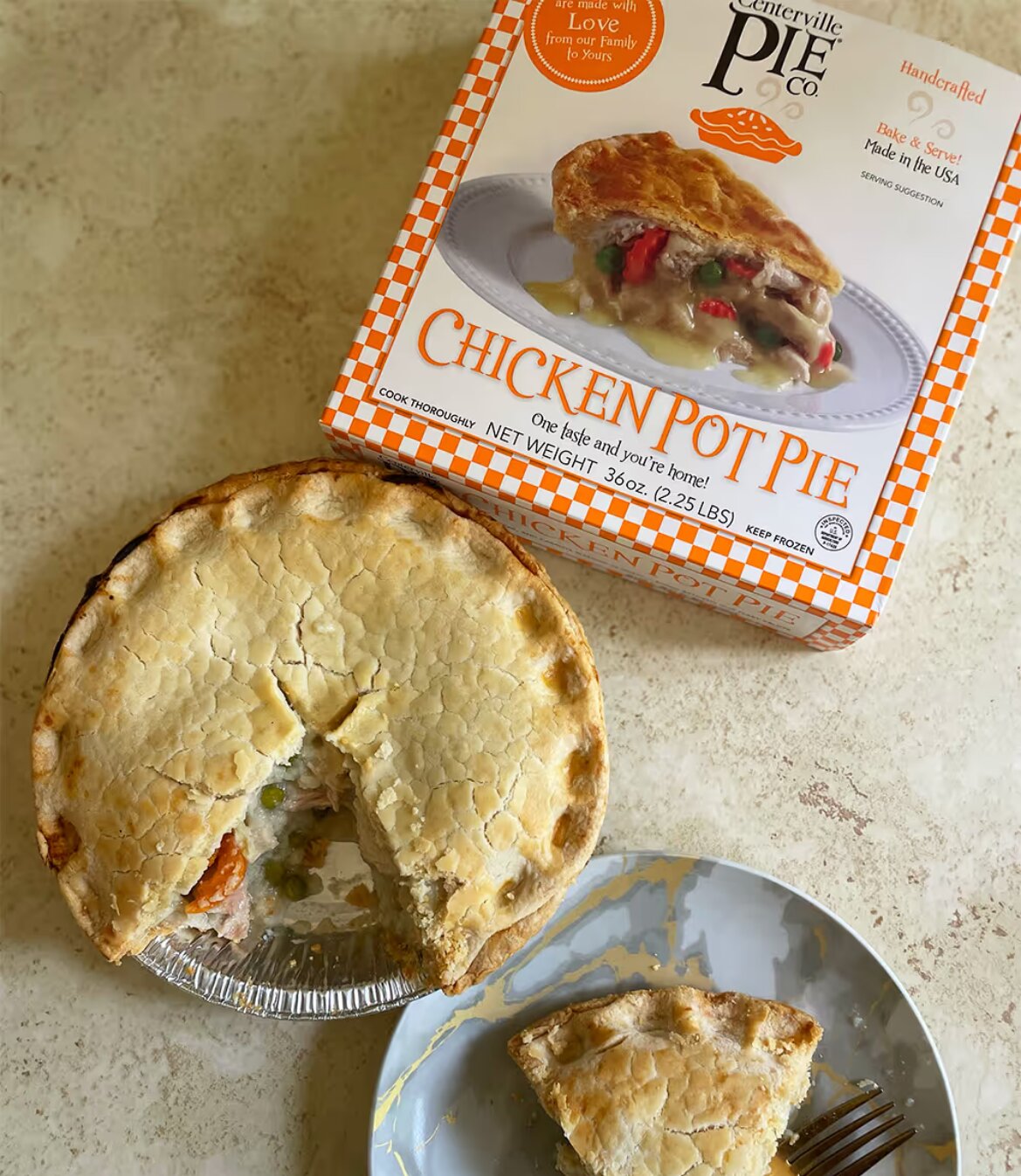 Centerville Pie Co. chicken pot pie beside packaging, with a slice removed showing vegetables and creamy filling.