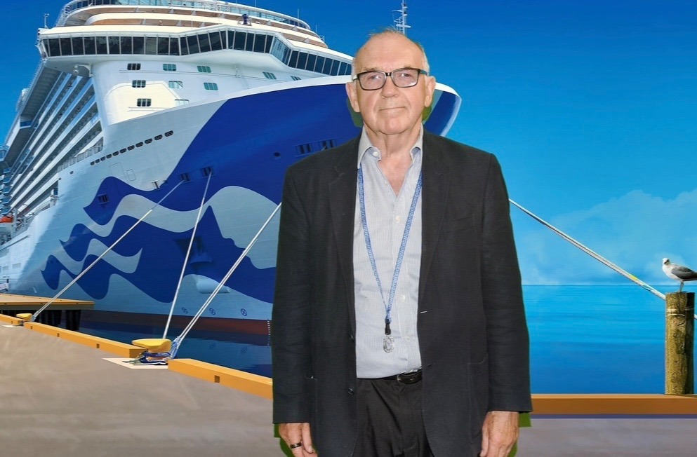 David Wortley standing before a cruise ship backdrop, representing global speaking and immersive experience leadership.
