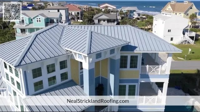 Aerial view of coastal home featuring a gray metal roof installed by Neal Strickland Roofing.