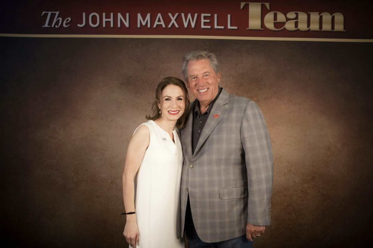 Darling Jarquín posing with leadership expert John Maxwell at a professional event.