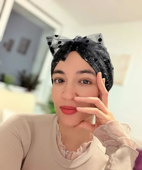 Professional woman in a black headscarf seated in a stylish café booth.