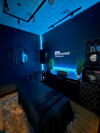 Modern Eros Bodyworks treatment room featuring ambient lighting and a premium wellness spa environment.