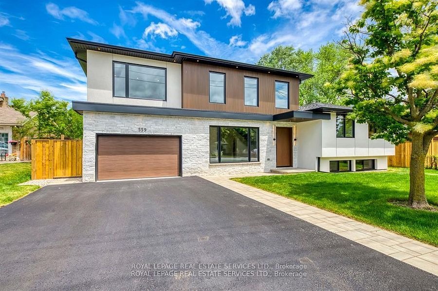 Modern two-story Burlington home with stone facade, double garage, and landscaped front yard