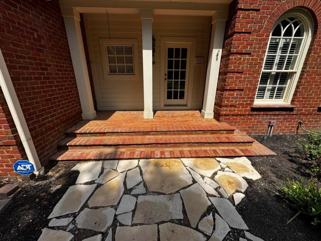 Stone walkway and brick front steps at a historic home prepared for masonry restoration.