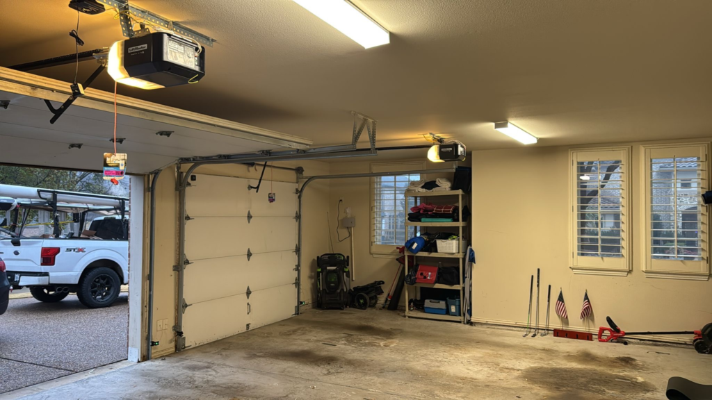 Residential garage interior with two garage doors and ceiling-mounted LiftMaster openers.